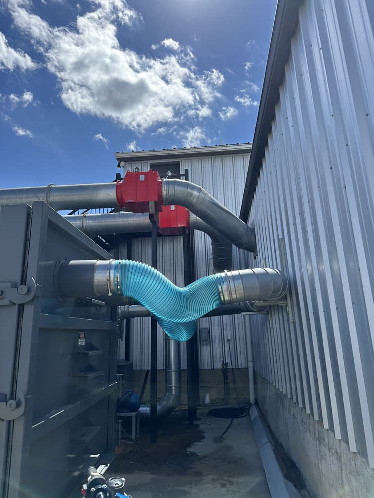 Exterior combustible dust ductwork with explosion isolation valves on an industrial building