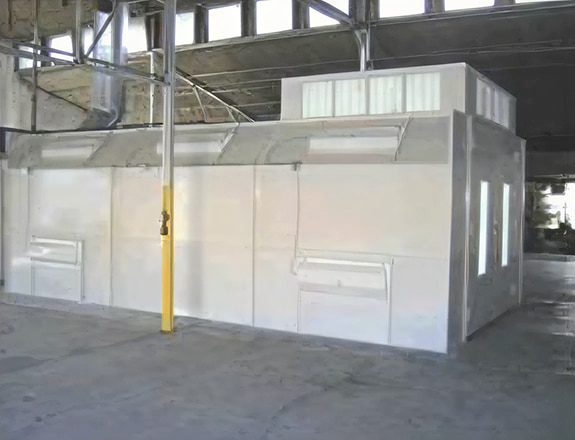 Industrial crossdraft spray booth with exhaust ventilation system installed in warehouse facility