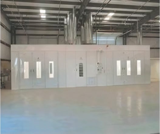 Large industrial paint booth systems installed side by side in manufacturing warehouse